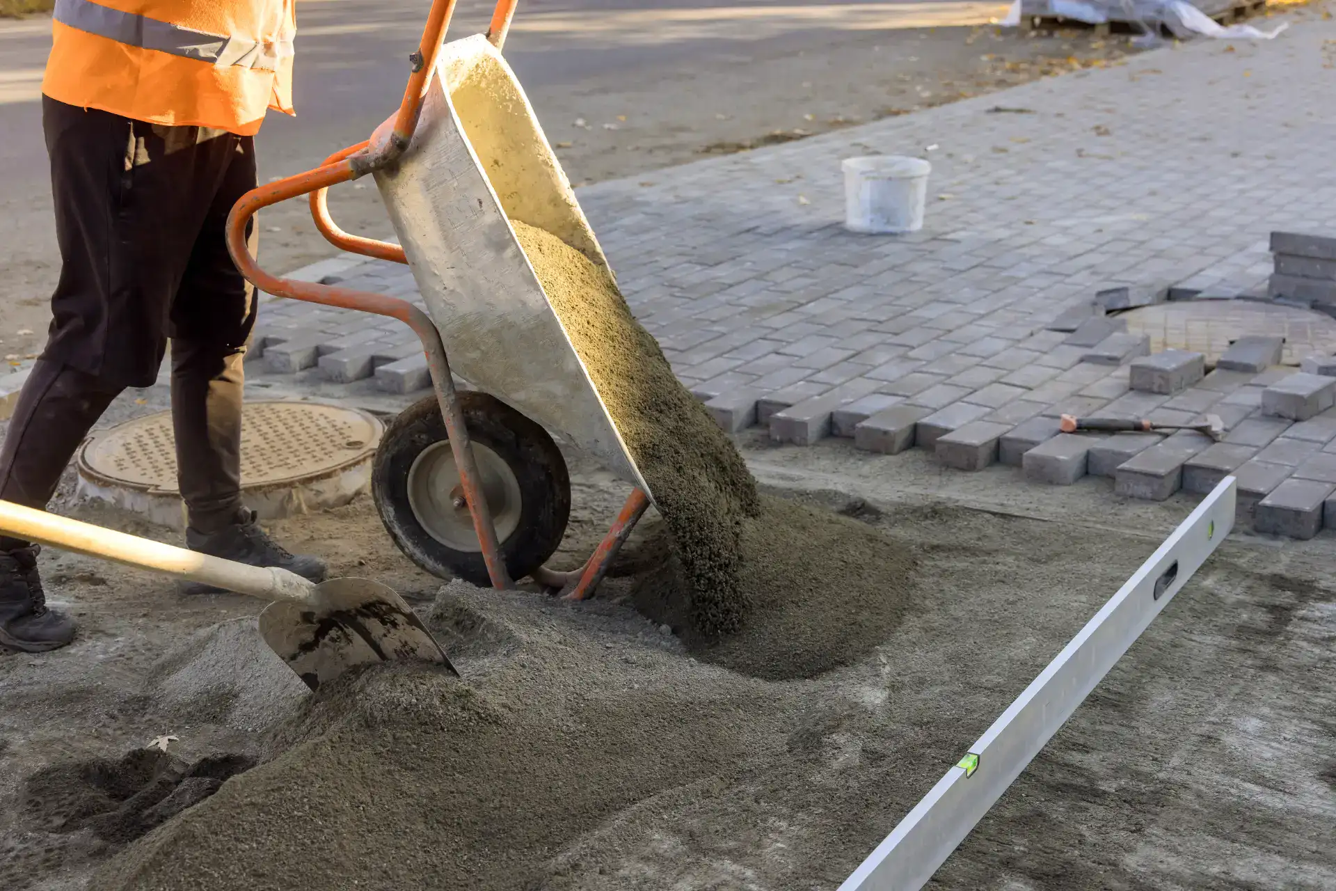 Arbejder med beton og belægningssten på en byggeplads.