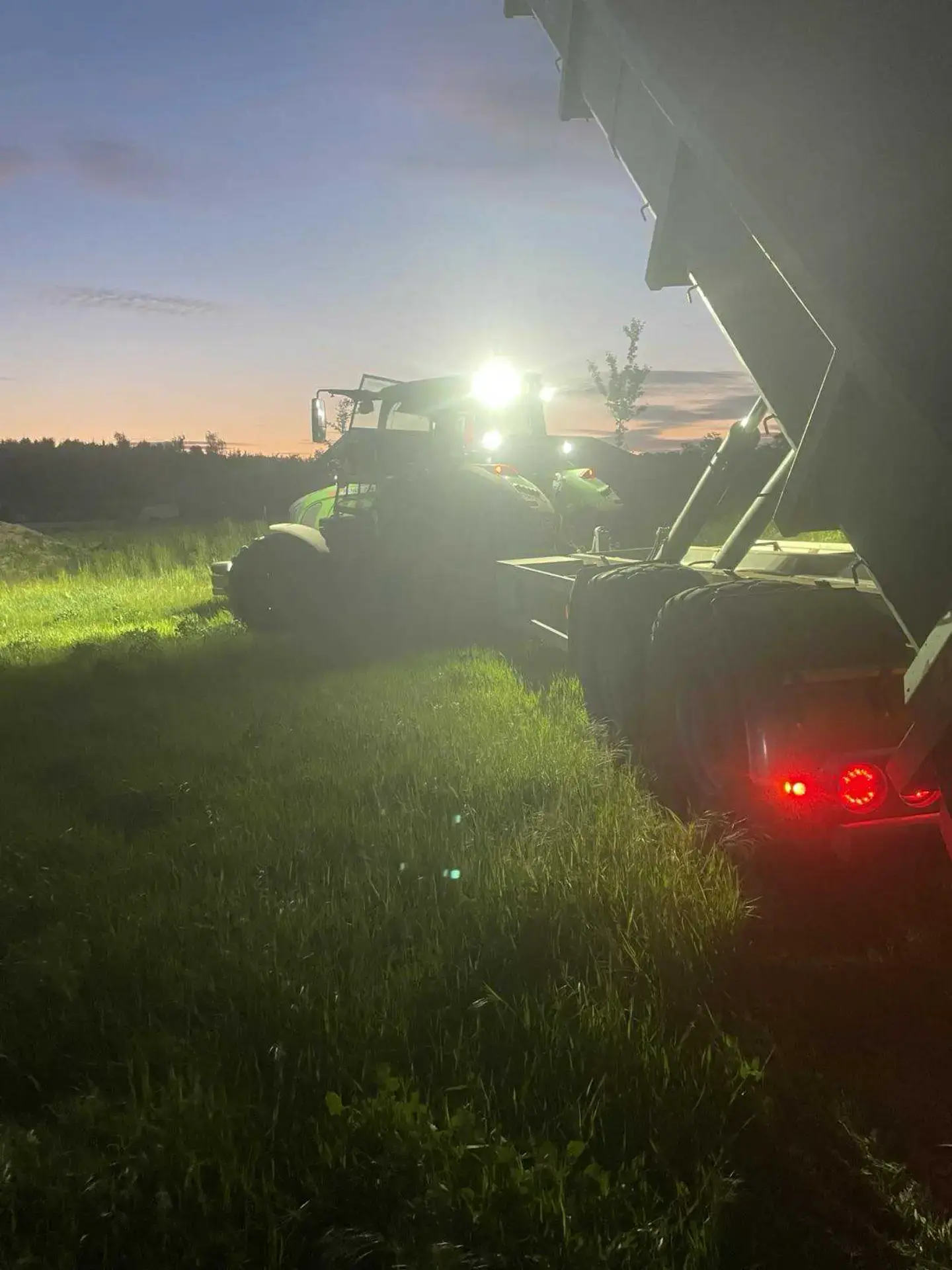 Høstmaskine i market ved solnedgang, landbrugs- og entreprenørarbejde.